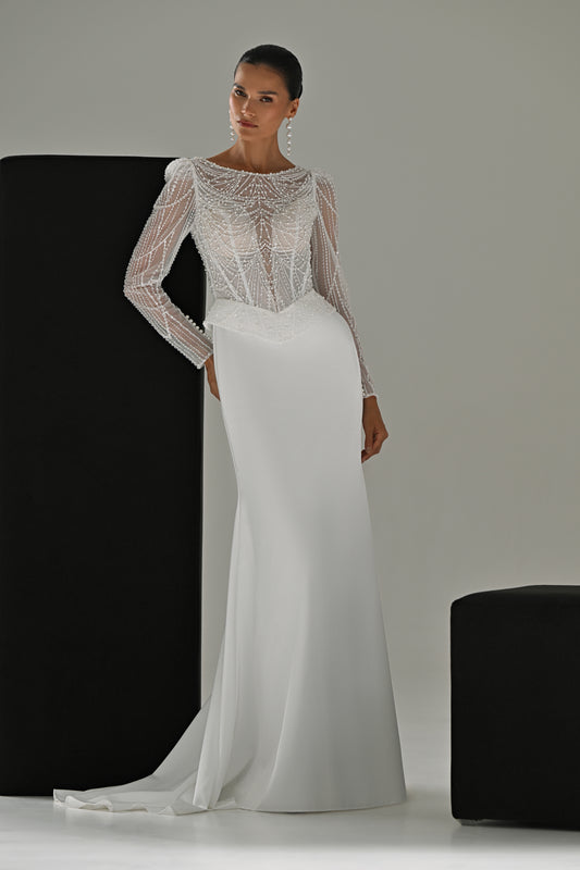Beaded lace sheath wedding dress with illusion neckline and long sleeves – full-length front view leaning on a black block