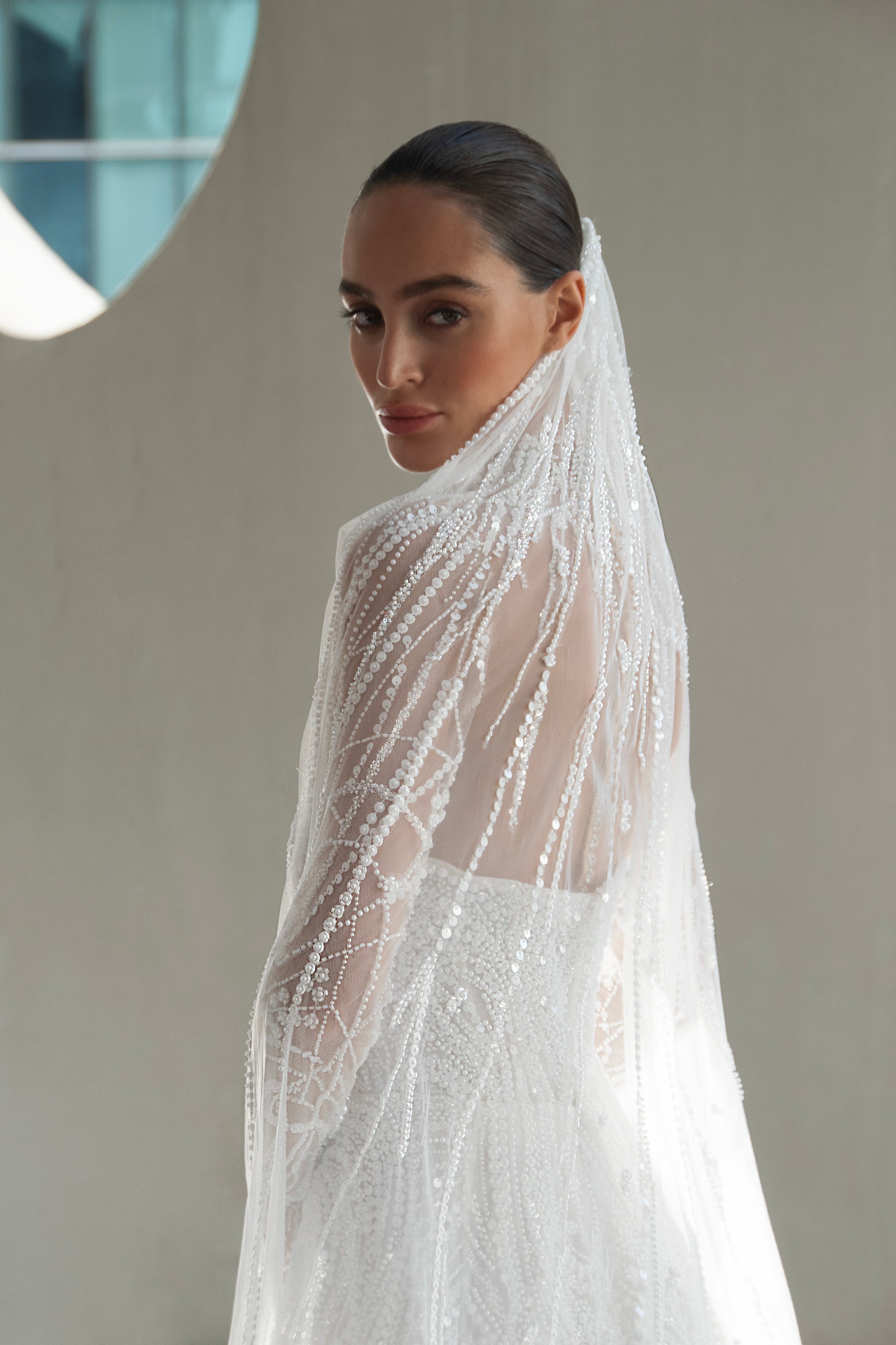 beaded A-line bridal gown with detachable illusion high-neck bolero, sheer long sleeves, button-back, and chapel train.