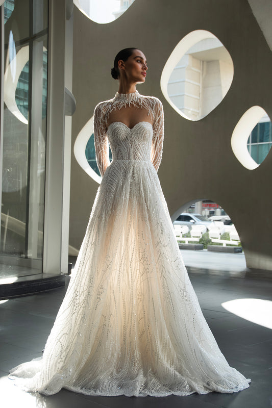 Back view of beaded A-line bridal gown with detachable illusion high-neck bolero, sheer long sleeves, button-back, and chapel train.