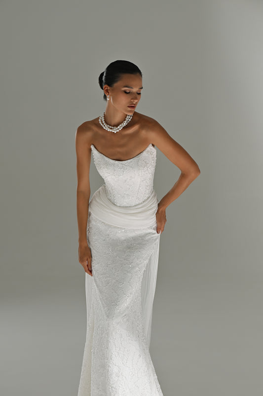 Strapless lace mermaid wedding dress with draped hip train – front view, hand on hip