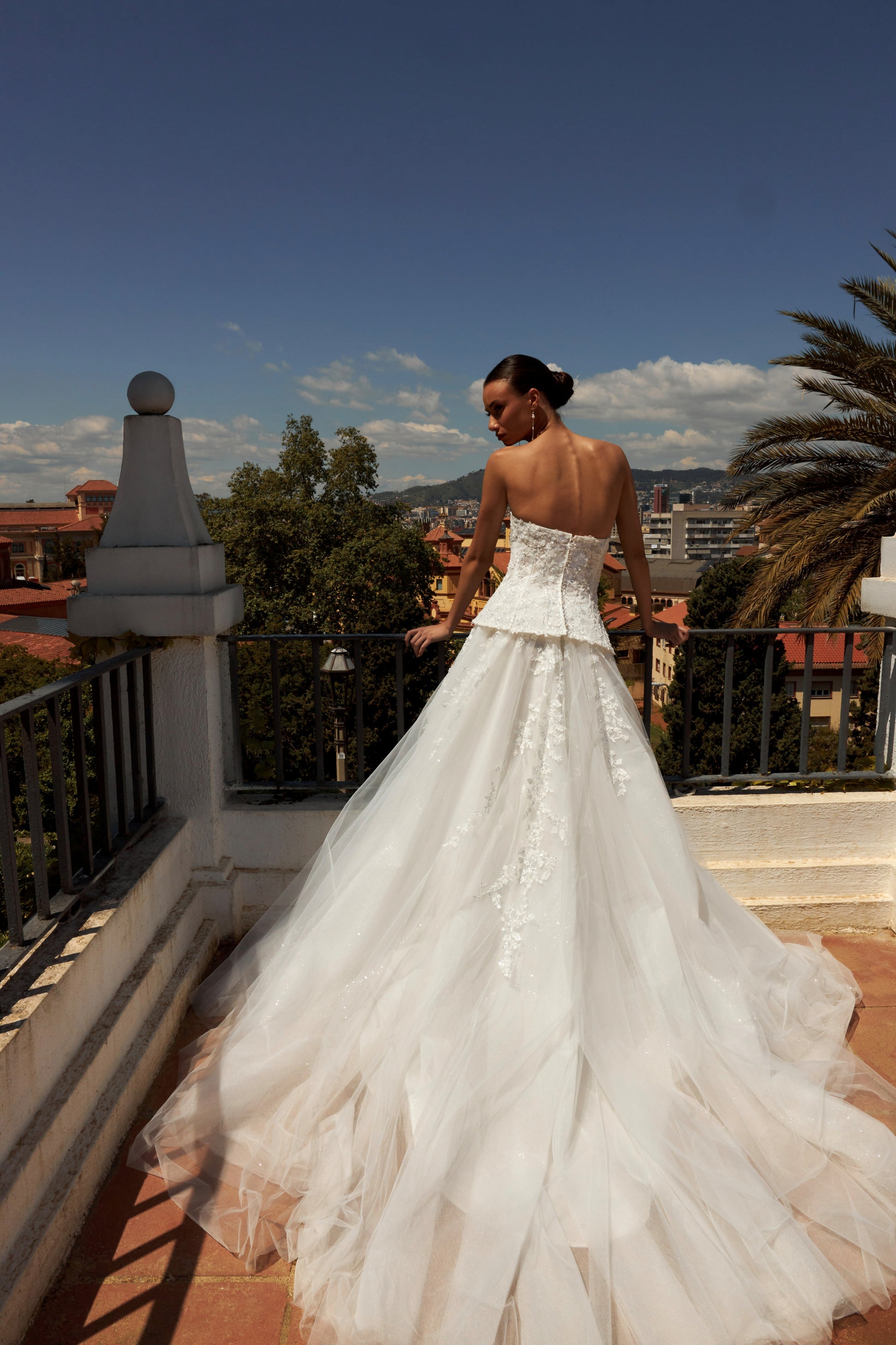 Bride in strapless sweetheart sleeveless A-line wedding gown with sequin lace corset, flowing tulle skirt, and chapel train.