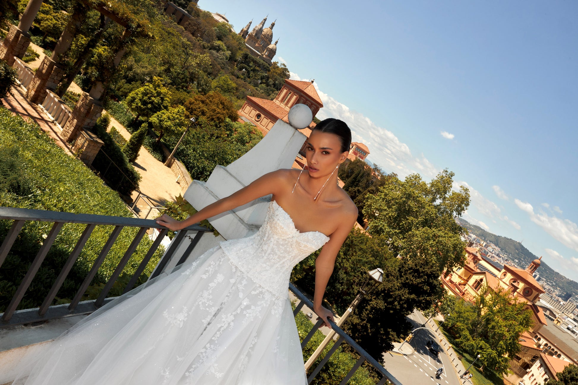 Bride in strapless sweetheart sleeveless A-line wedding gown with sequin lace corset, flowing tulle skirt, and chapel train.