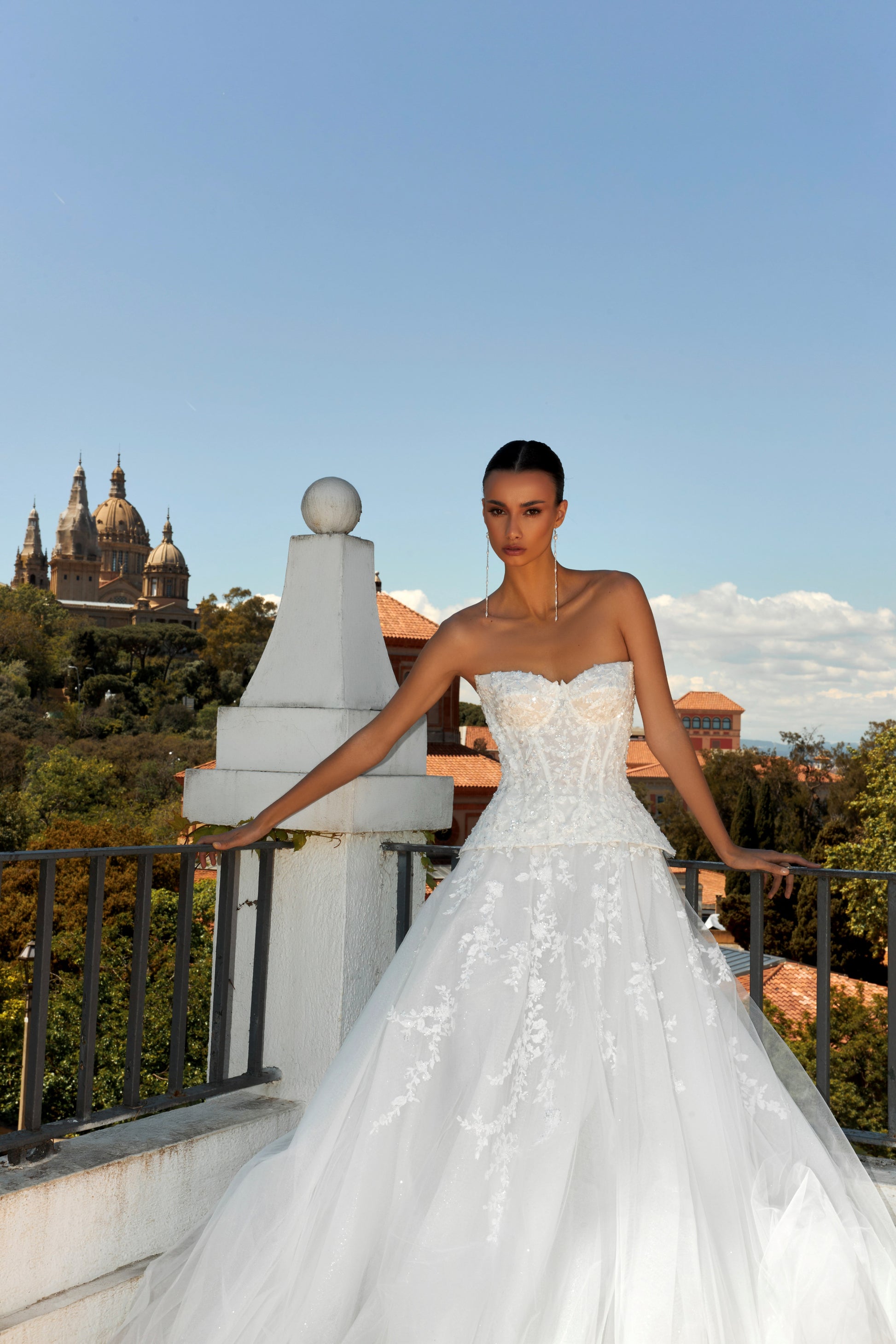 Bride in strapless sweetheart sleeveless A-line wedding gown with sequin lace corset, flowing tulle skirt, and chapel train.