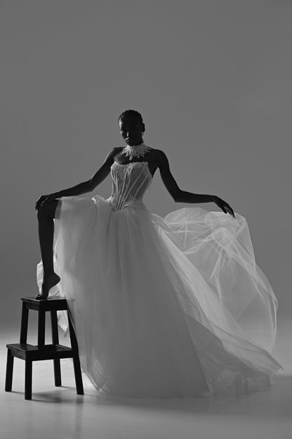 Tulle ball gown wedding dress – black and white pose on a stool with the tulle skirt