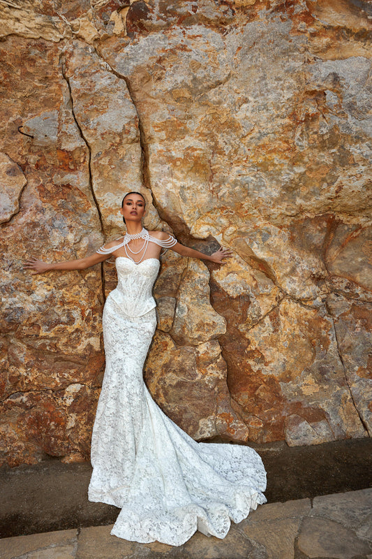 Mermaid wedding dress with sweetheart neckline, sleeveless pearl lace corset, longline bodice, and fishtail court train. Luxurious modern bridal gown.