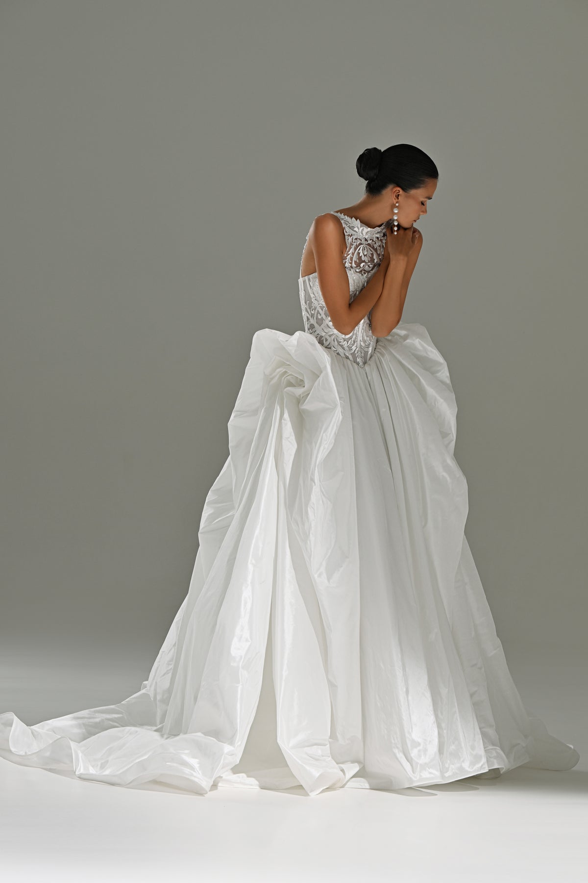 Taffeta ball gown wedding dress with draped bow skirt – three-quarter view with the long train