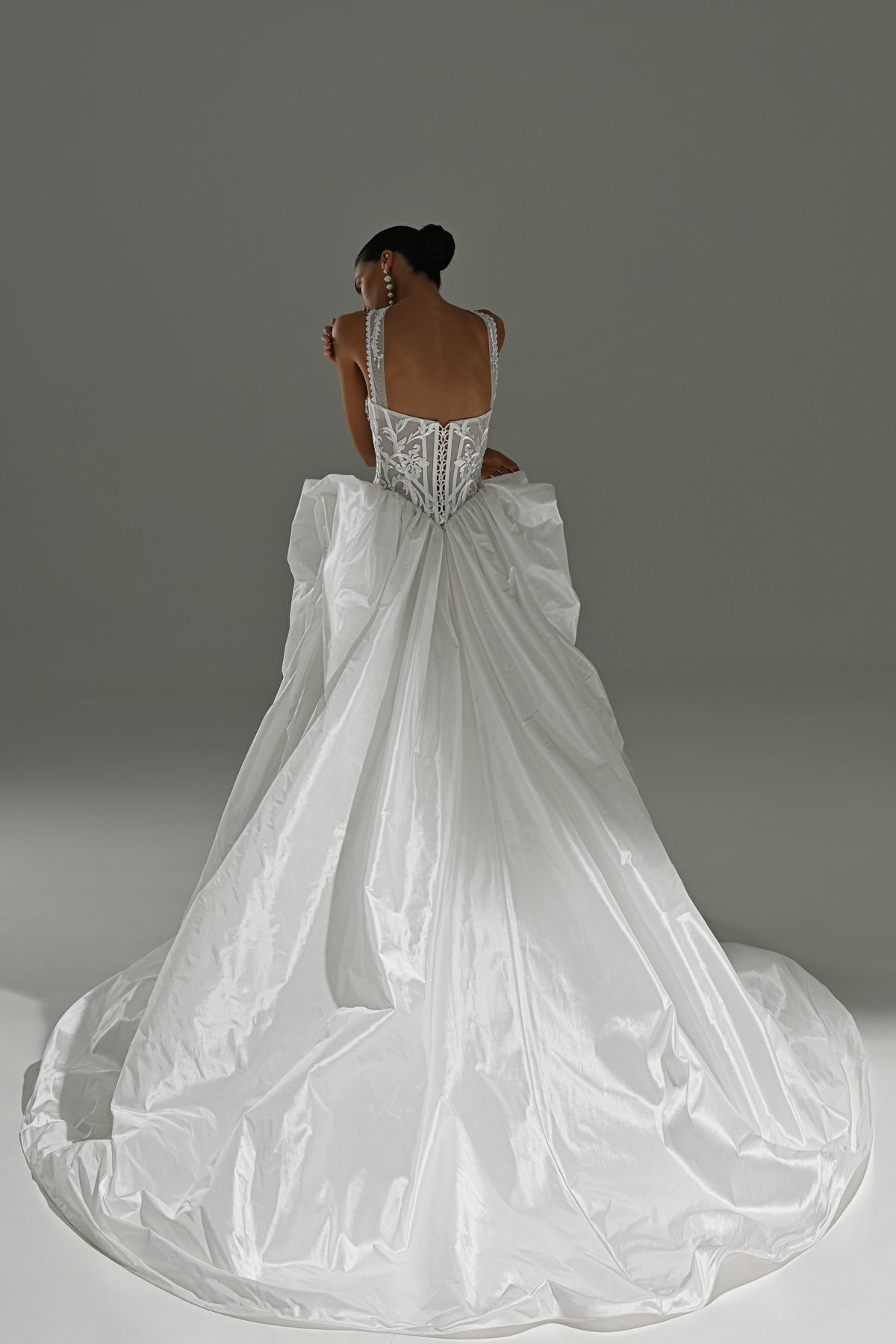 Taffeta ball gown wedding dress with draped bow skirt – back view of the open back and bow