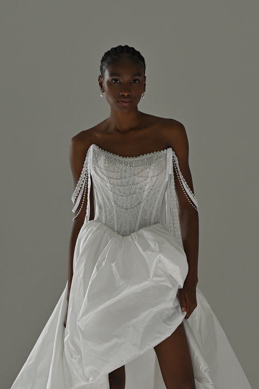 Taffeta wedding dress with lace corset and beaded fringe straps – front view lifting the high-slit overskirt