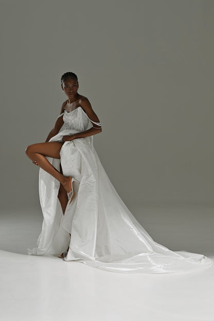 Taffeta wedding dress with high-slit overskirt – model posing with one leg raised, train behind