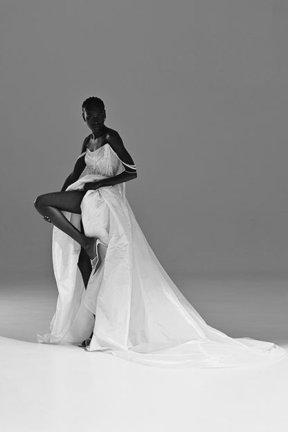 Taffeta wedding dress with high-slit overskirt – black and white pose with one leg raised