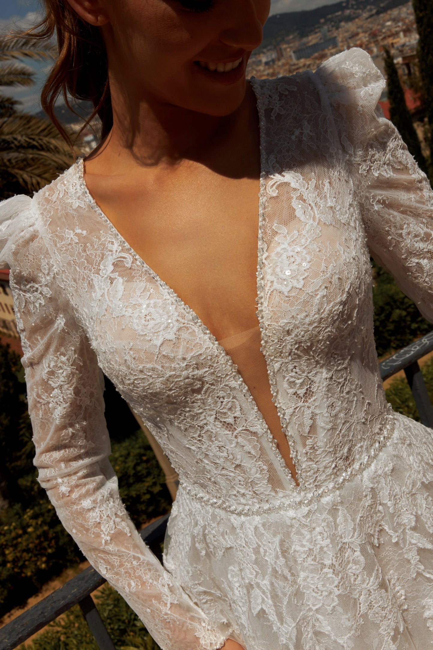 Bride in long sleeve lace A-line bridal gown with puffy shoulders, illusion deep-V back, button closure, and chapel train.