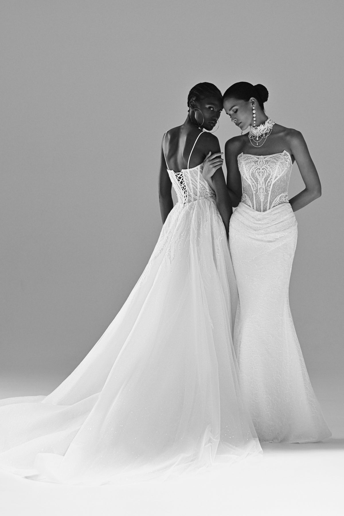 Lace sheath wedding dress – black and white full-length view of two brides side by side