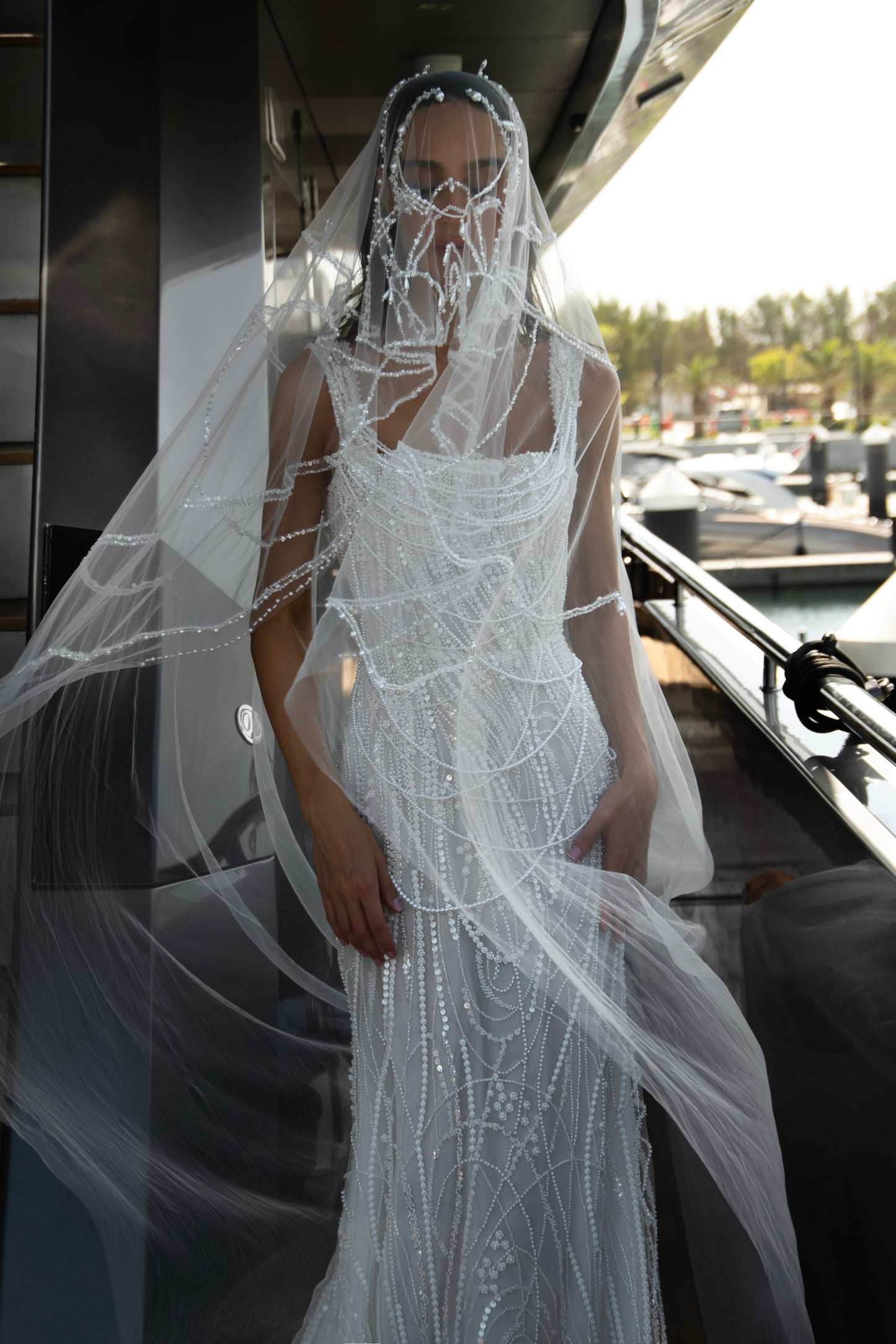 Sculpted beaded mermaid wedding gown with scoop neckline, pearl-inspired detailing, and soft tulle chapel train.