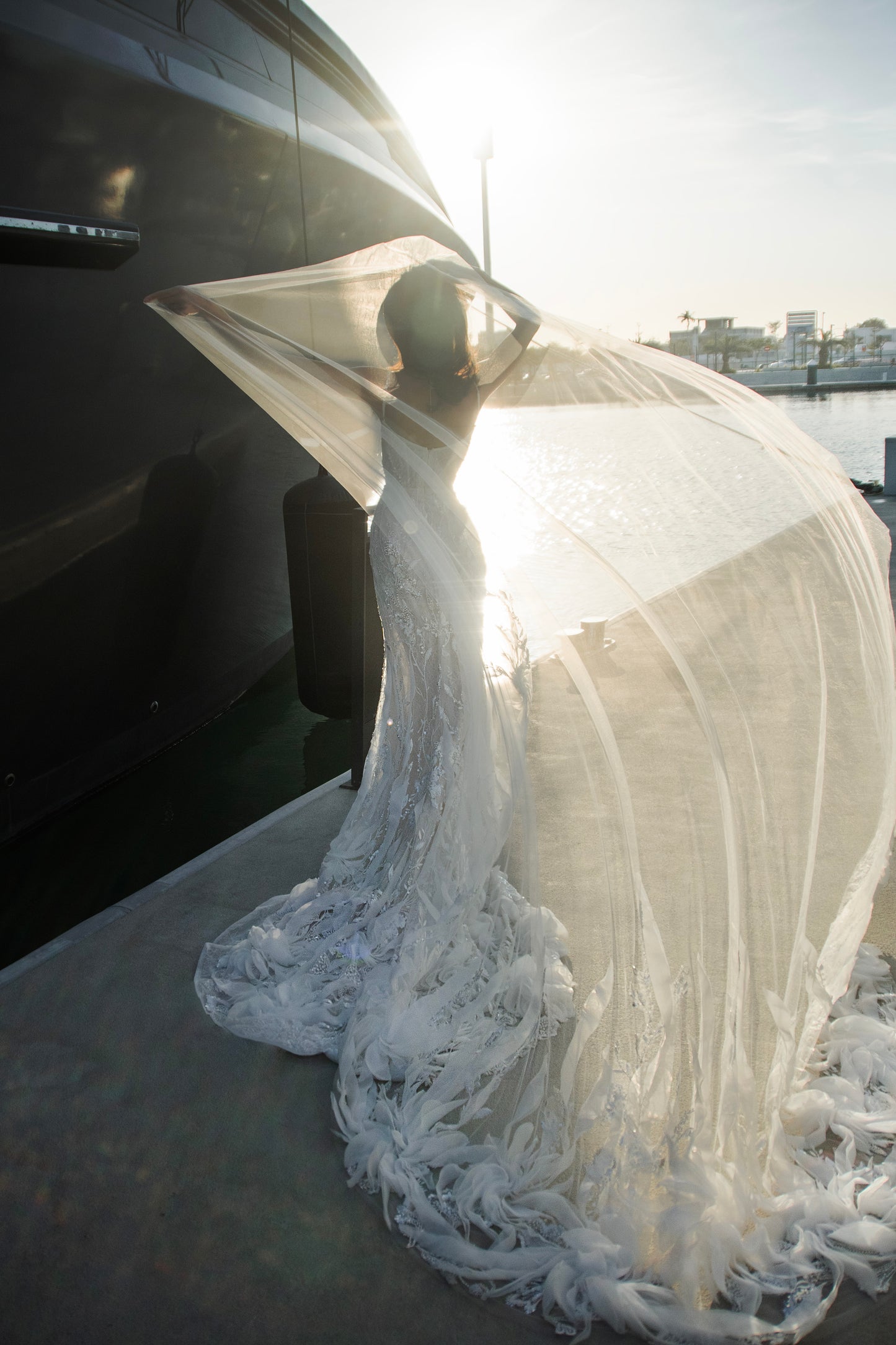Beaded sheath wedding dress with illusion corset bodice and feather-textured tulle chapel train.