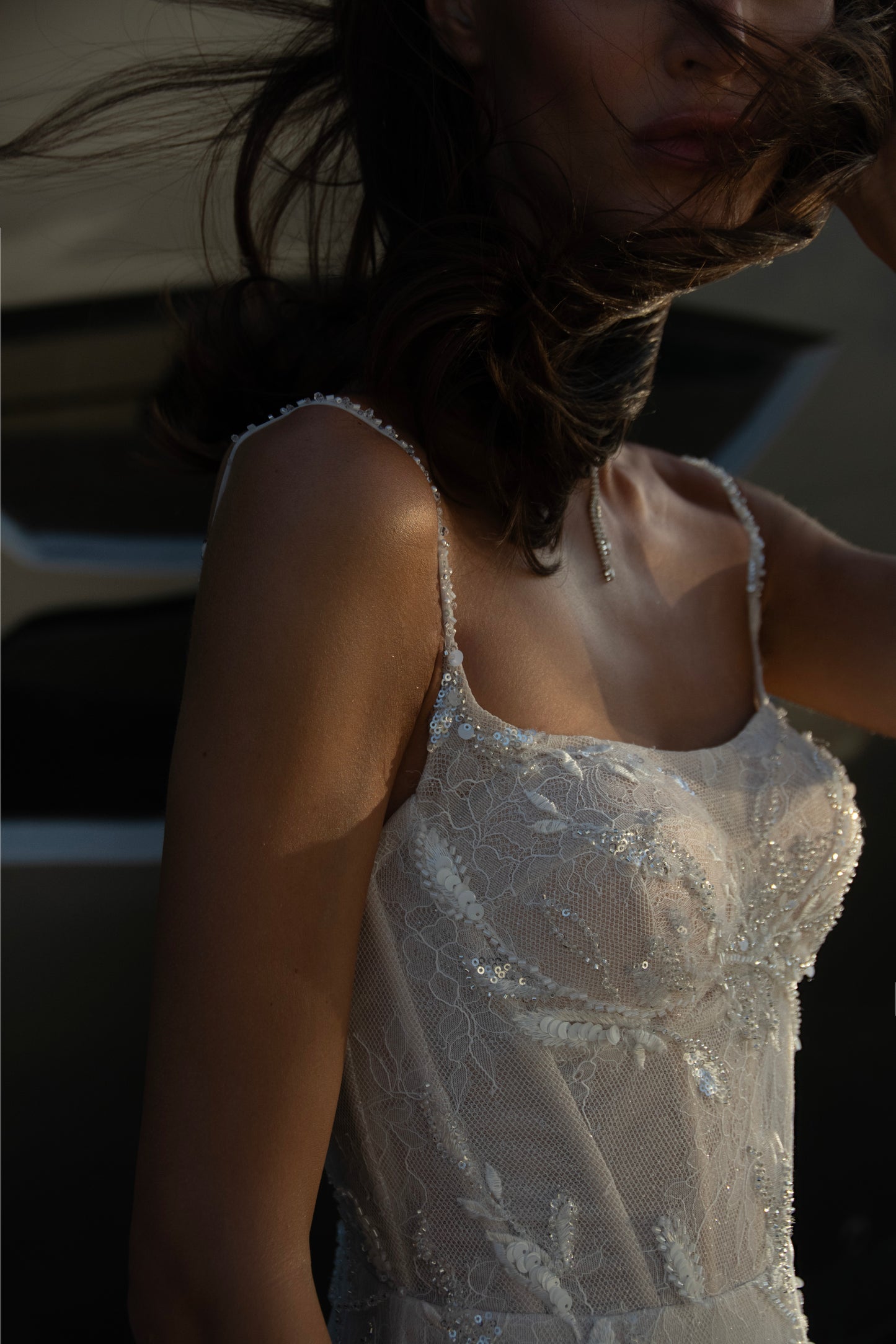 Beaded sheath wedding dress with illusion corset bodice and feather-textured tulle chapel train.