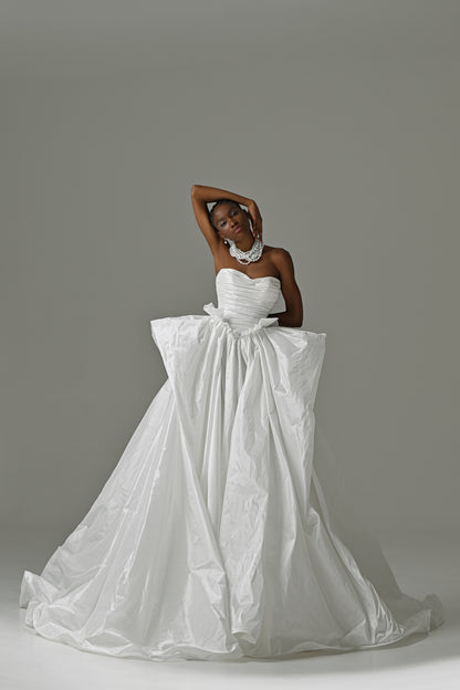 Strapless taffeta ball gown wedding dress with ruched bodice and oversized bow – full-length front view, arms overhead