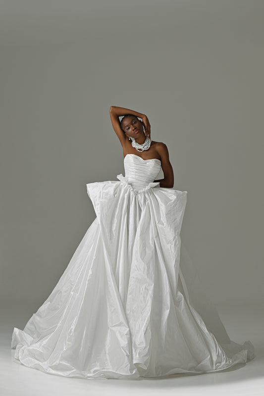 Strapless taffeta ball gown wedding dress with ruched bodice and oversized bow – full-length front view, arms overhead