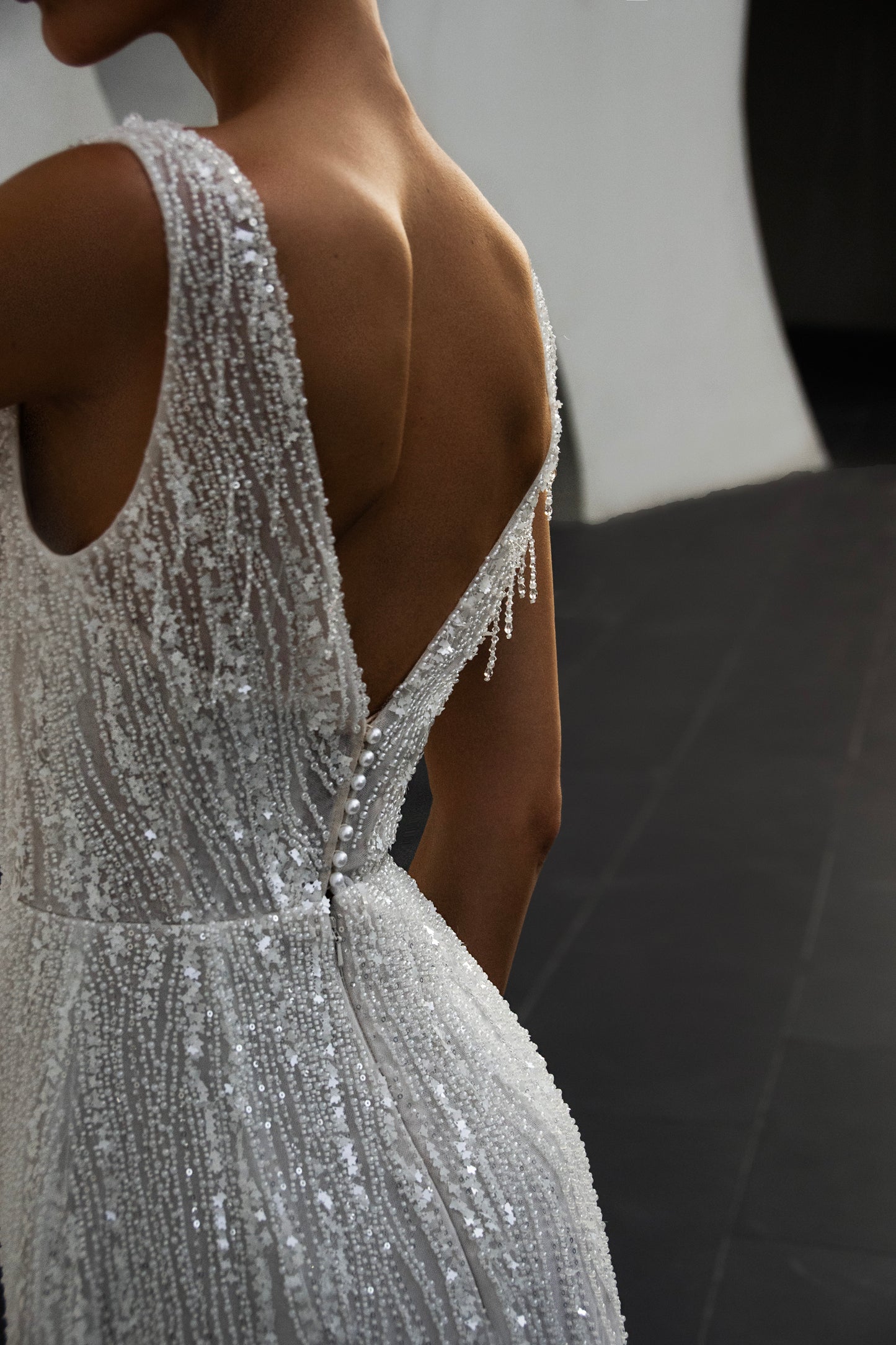 Radiant beaded A-line wedding gown with deep V neckline and open back, featuring a soft flowing tulle train.