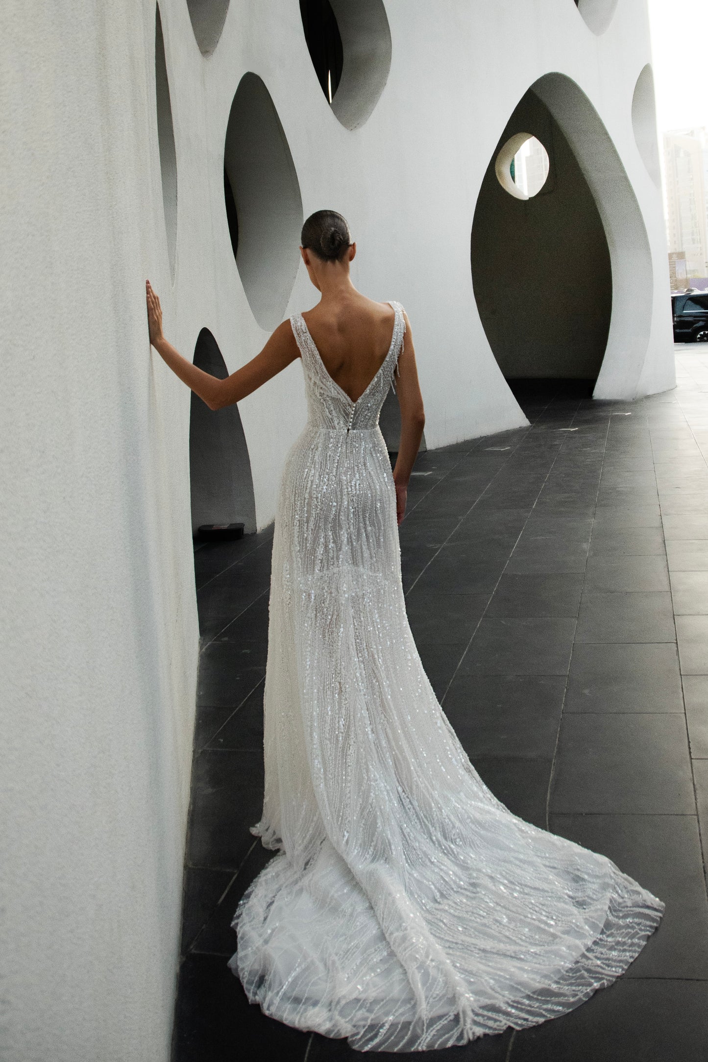 Radiant beaded A-line wedding gown with deep V neckline and open back, featuring a soft flowing tulle train.