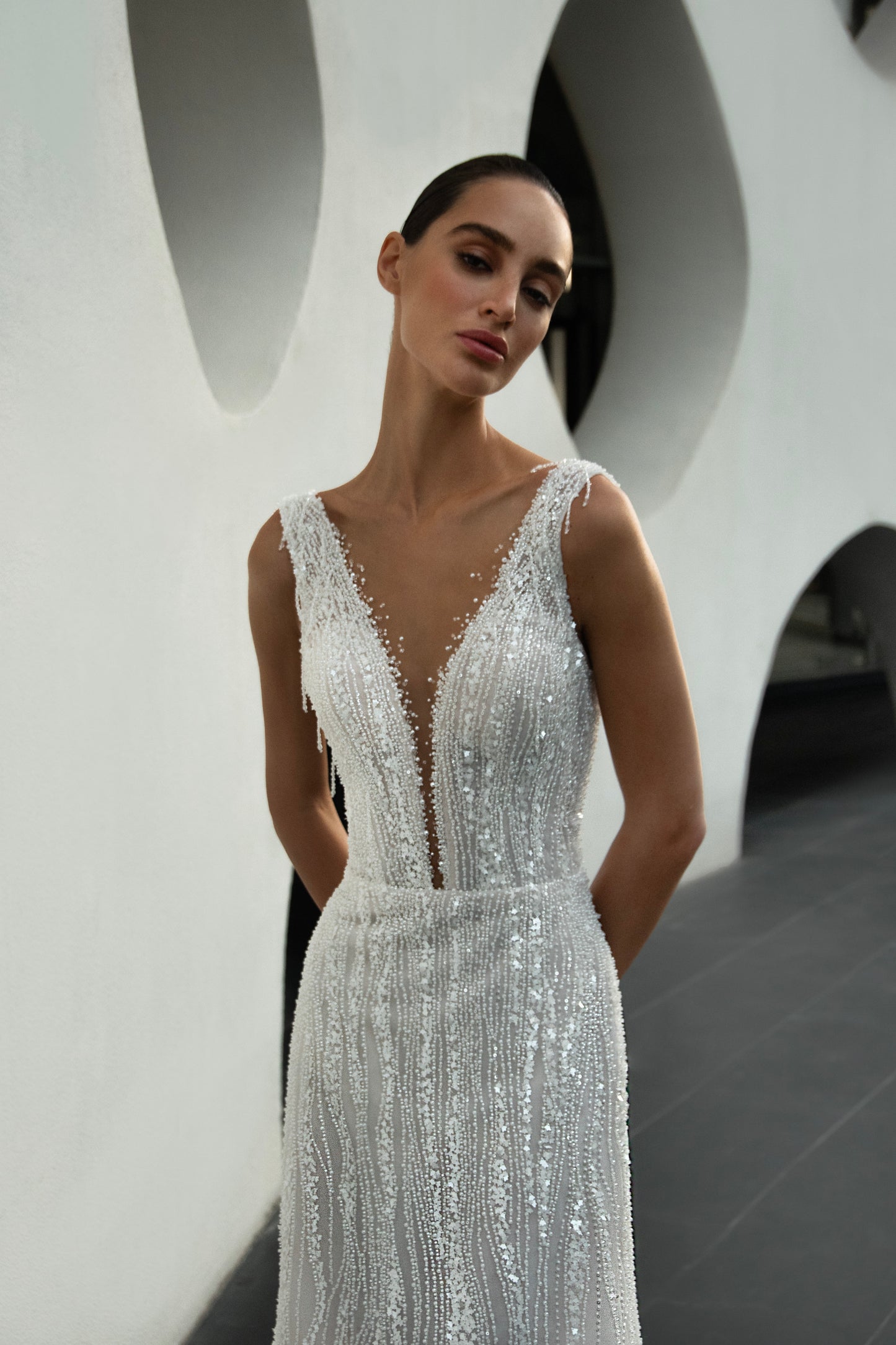 Radiant beaded A-line wedding gown with deep V neckline and open back, featuring a soft flowing tulle train.