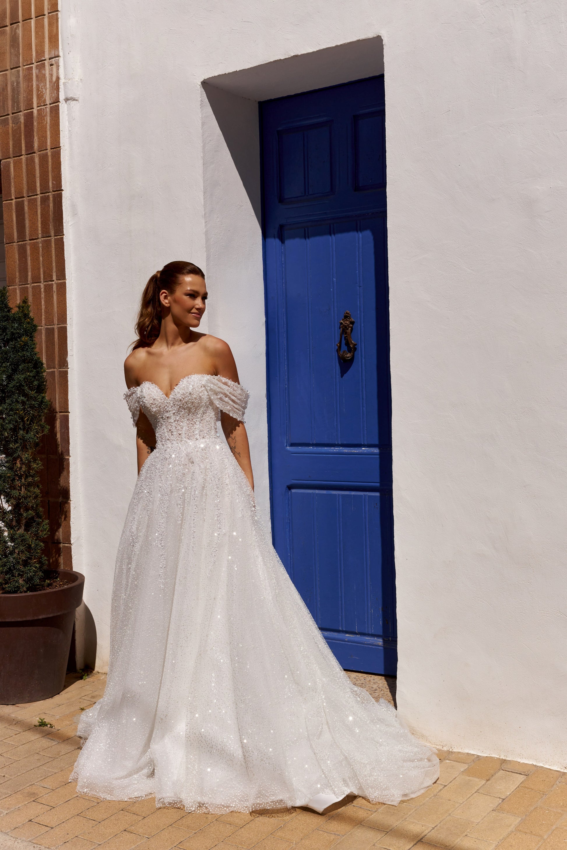 Sleeveless A-line lace bridal gown with sweetheart neckline, pearl straps, pearl and sequin embroidery, and glittering tulle skirt.