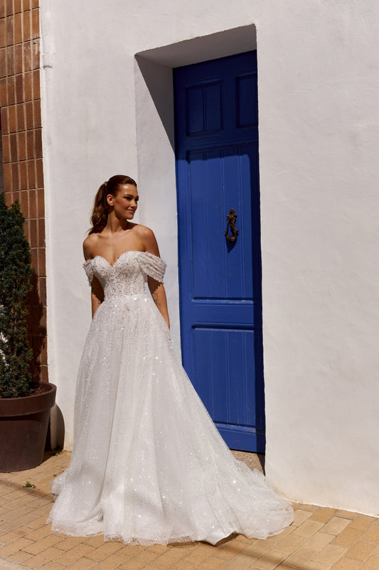 Sleeveless A-line lace bridal gown with sweetheart neckline, pearl straps, pearl and sequin embroidery, and glittering tulle skirt.