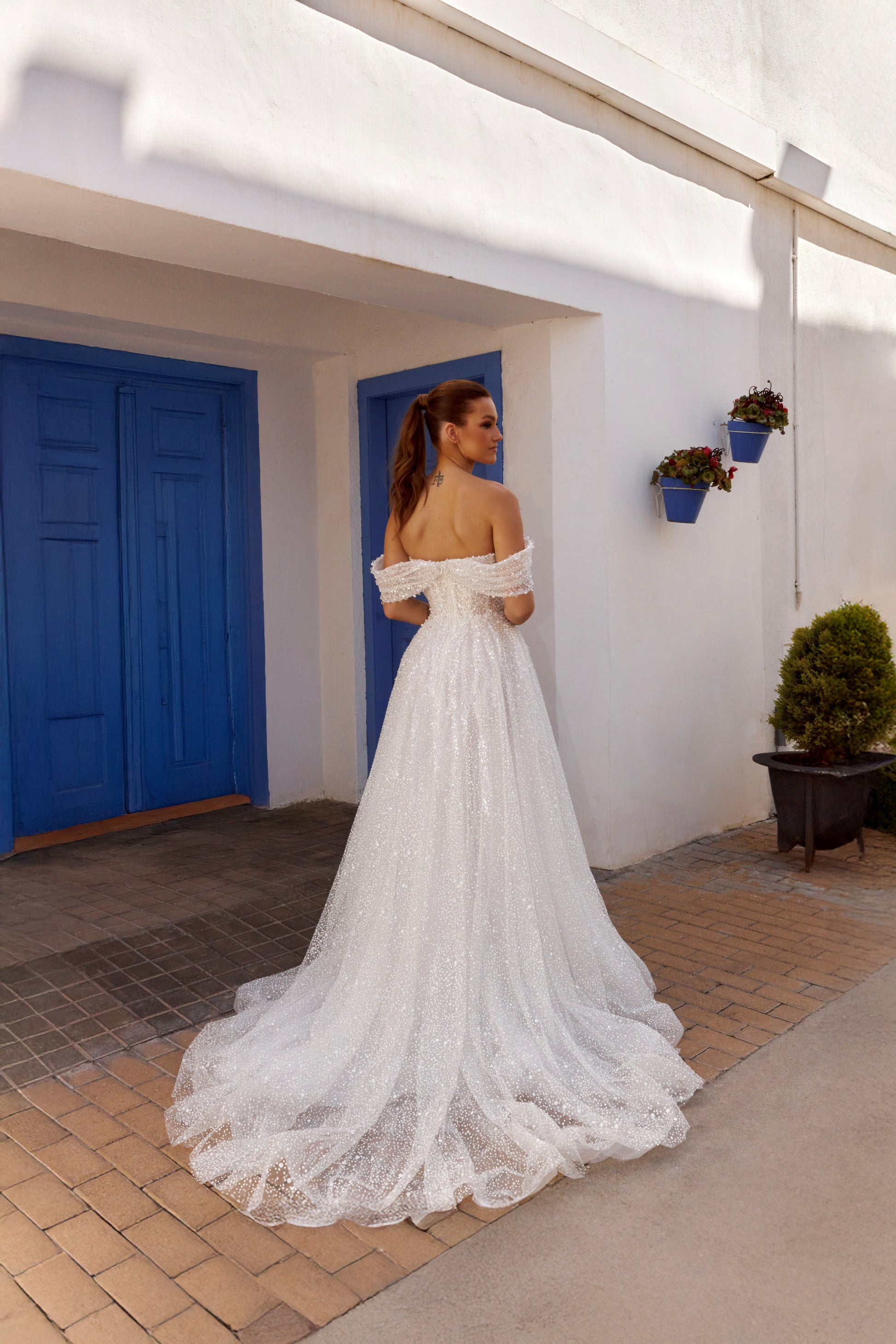 Sleeveless A-line lace bridal gown with sweetheart neckline, pearl straps, pearl and sequin embroidery, and glittering tulle skirt.