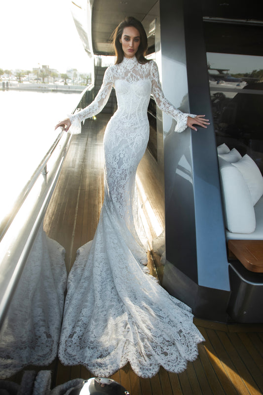 Vintage lace wedding gown with detachable bolero, long sleeves, and sweetheart corset bodice with scalloped lace train.
