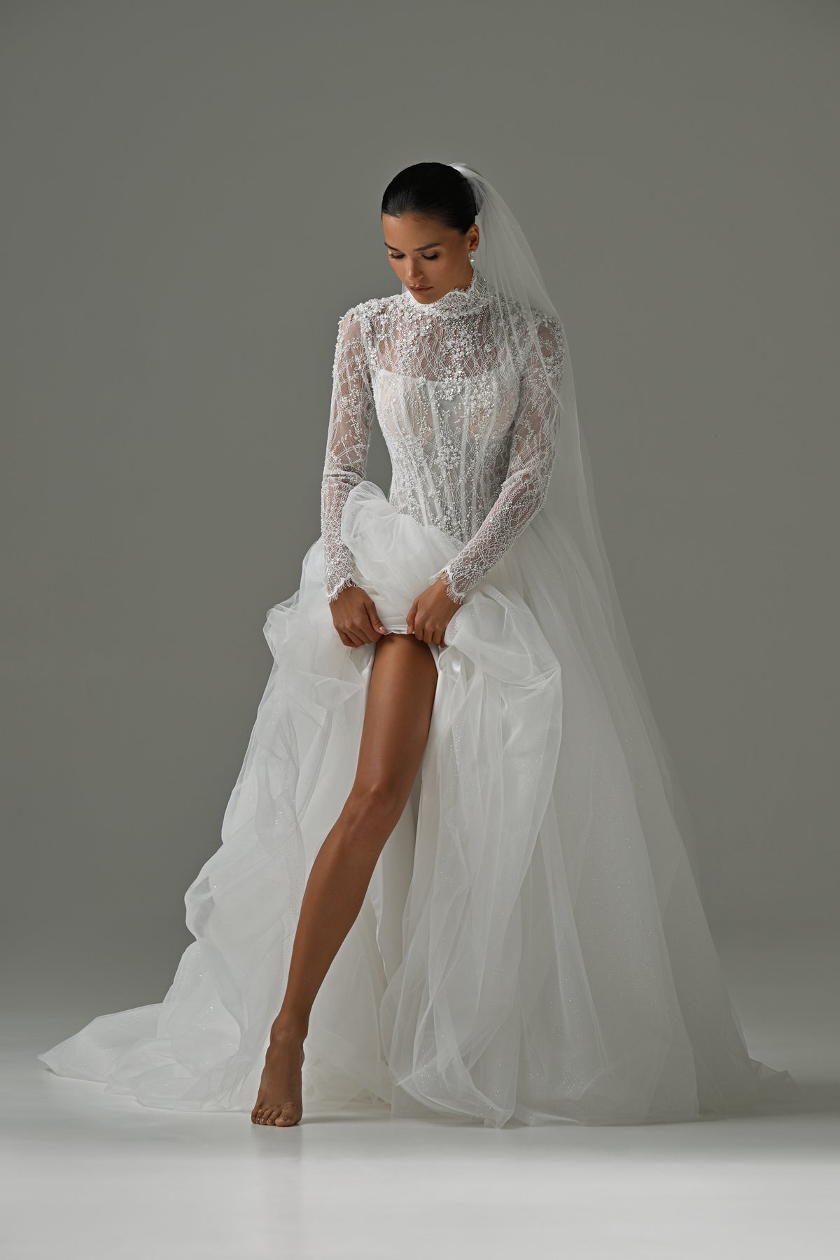 Lace high-neck wedding dress with tulle skirt – front view with the skirt lifted to show the leg slit