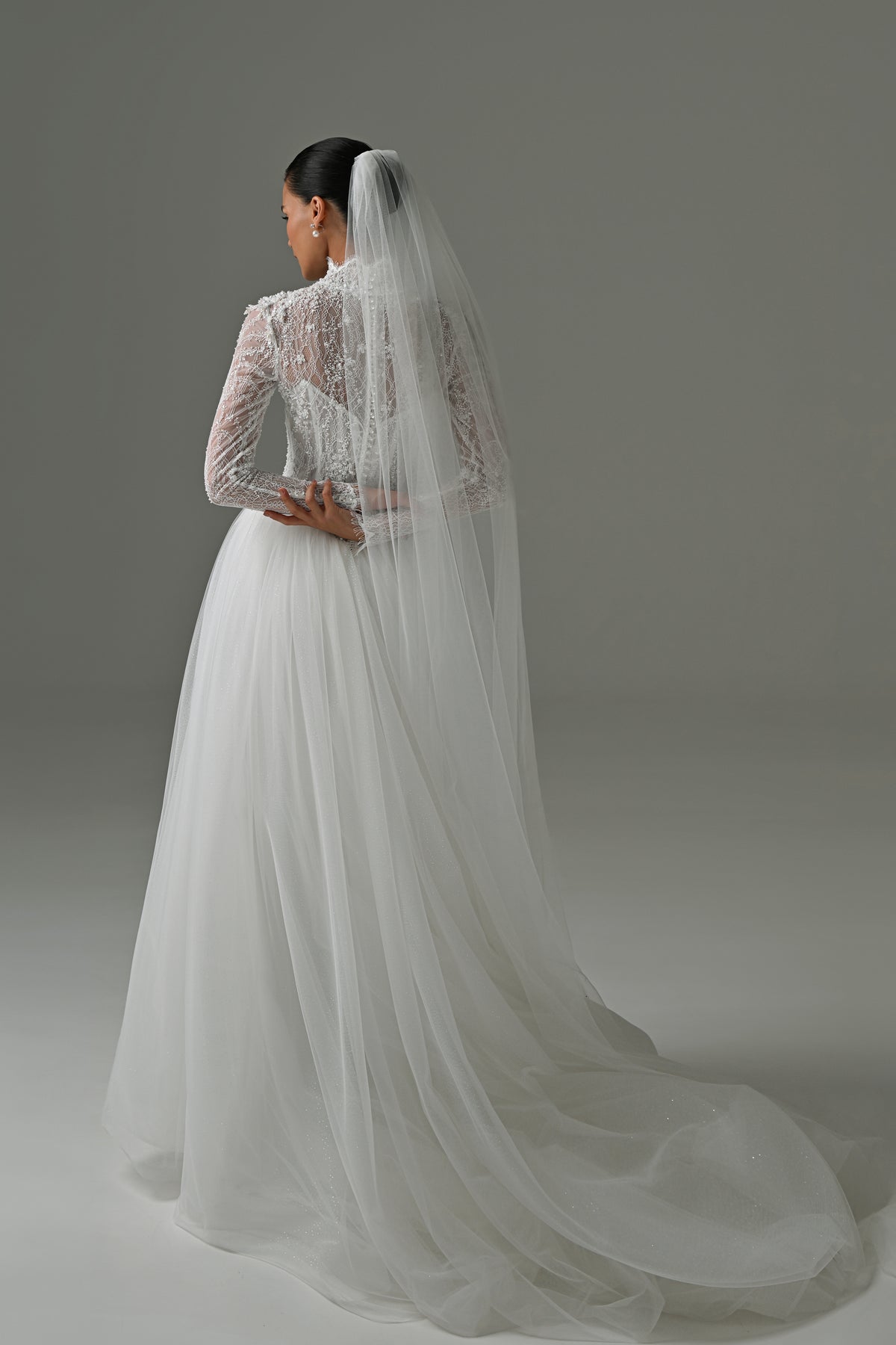 Lace high-neck wedding dress with long sleeves – back view with the long veil and tulle train