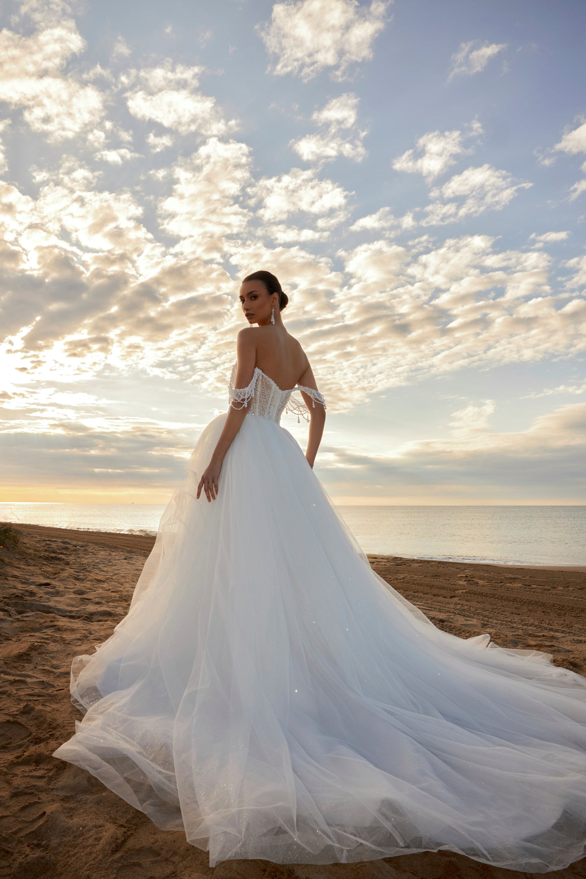 Sleeveless A-line wedding dress with pearl bodice, sweetheart neckline, glitter tulle skirt, off-the-shoulder pearl straps, and chapel train.