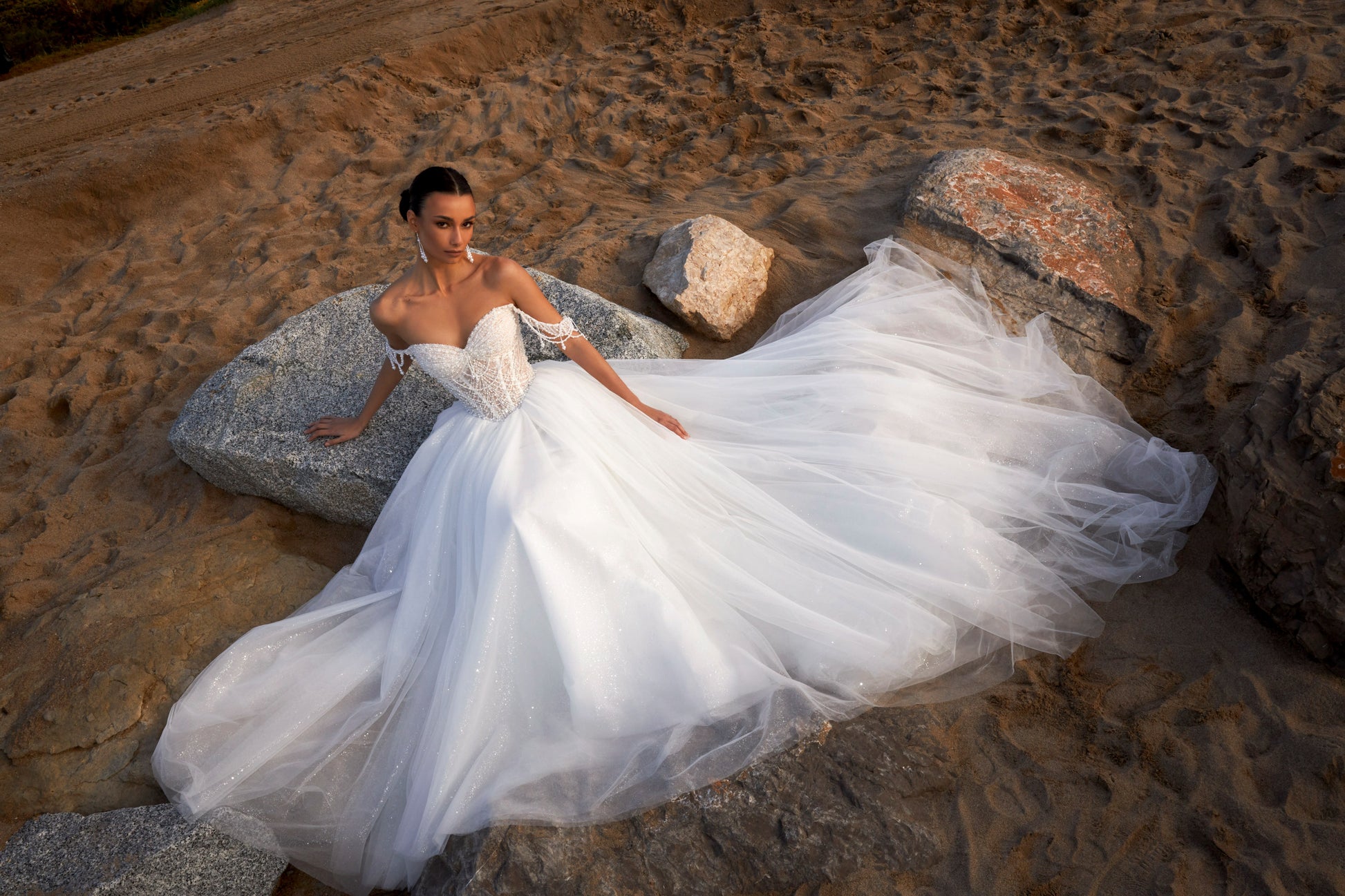 Sleeveless A-line wedding dress with pearl bodice, sweetheart neckline, glitter tulle skirt, off-the-shoulder pearl straps, and chapel train.