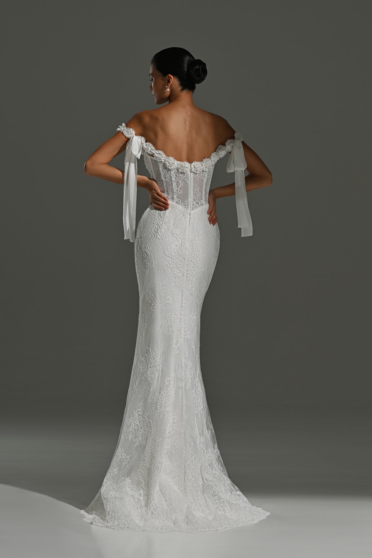 Fitted lace wedding dress with ribbon bows – back view of the lace corset and trailing ribbons