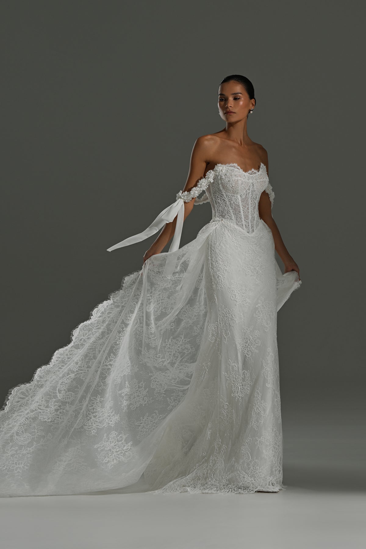 Lace wedding dress with detachable scalloped train – three-quarter view with the train flowing