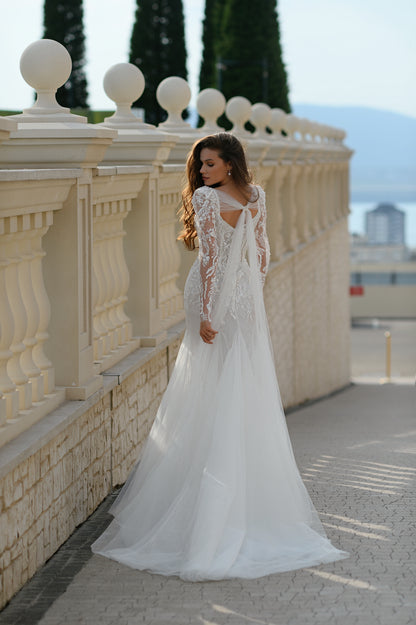 Mermaid wedding dress with long sleeves, bow, and fishtail train