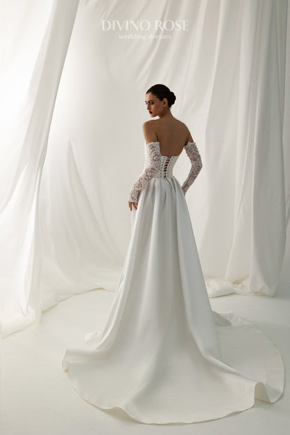 Fitted wedding dress with lace sleeves and corset back.