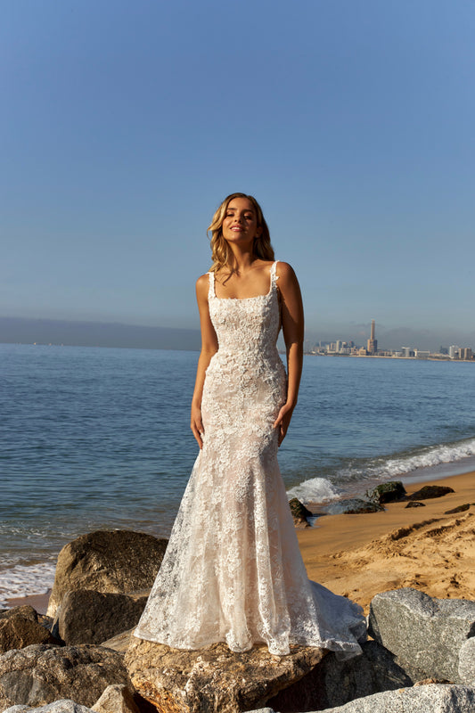 Mermaid trumpet lace bridal gown with square neckline, wide straps, open square back, zip closure, and fishtail train.