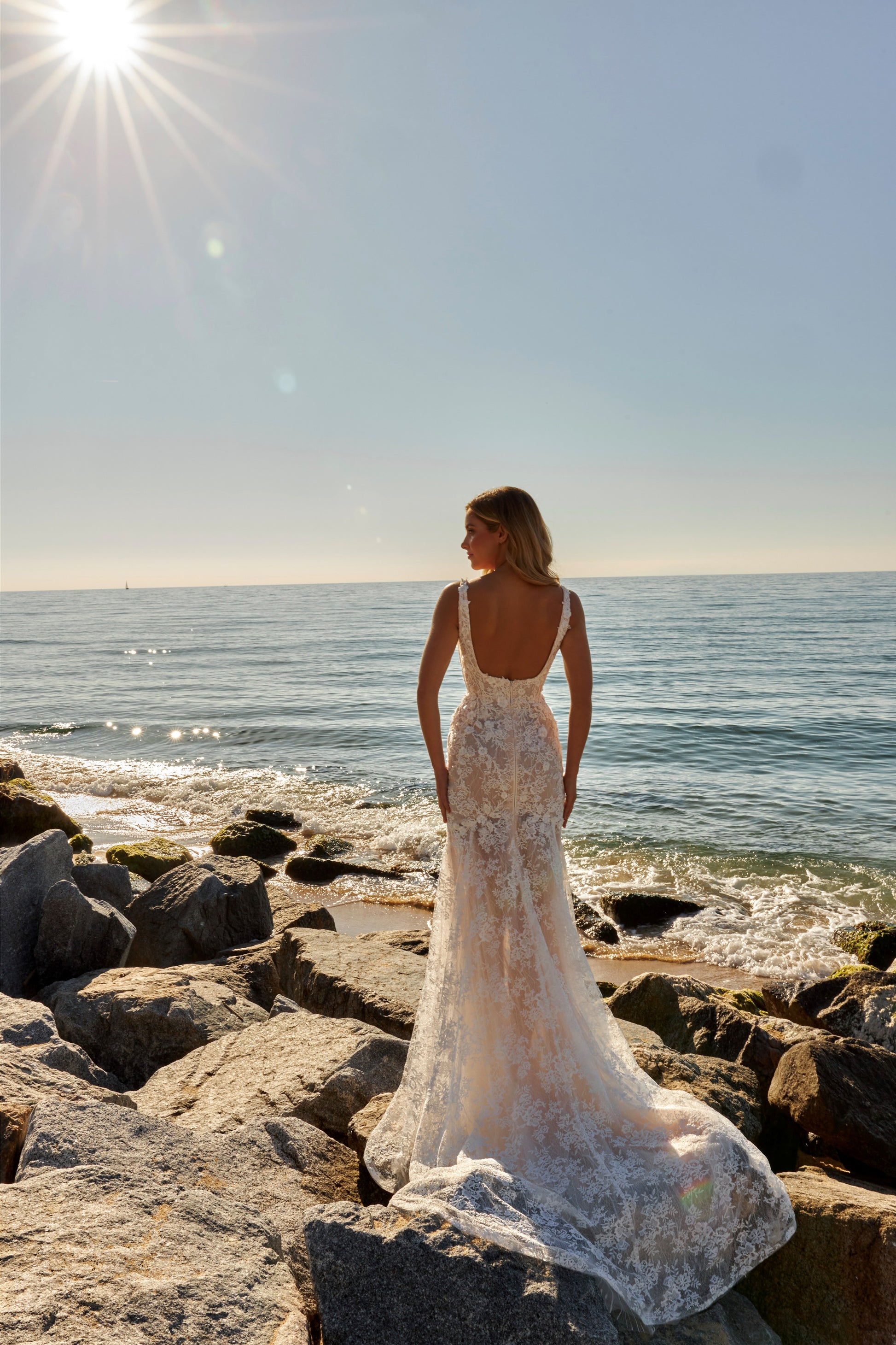 Mermaid trumpet lace bridal gown with square neckline, wide straps, open square back, zip closure, and fishtail train.