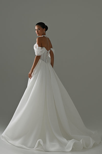 Off-shoulder organza A-line wedding dress with puff sleeves and lace corset – back three-quarter view of the full skirt