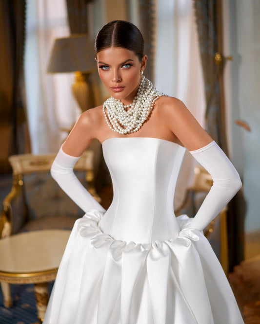 Full-length Mikado A-line wedding dress with straight neckline, prolonged waist, puffy bubble-hem skirt, removable long gloves, open straight-cut back, and lace-up closure for modern bridal style