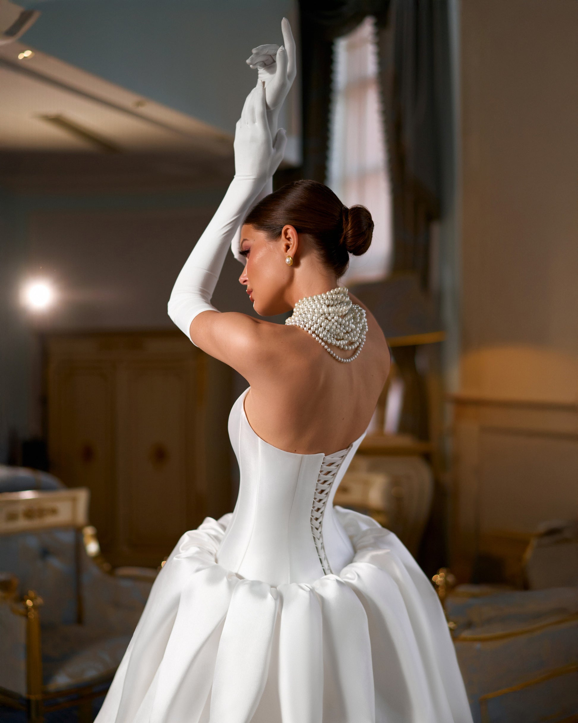 Full-length Mikado A-line wedding dress with straight neckline, prolonged waist, puffy bubble-hem skirt, removable long gloves, open straight-cut back, and lace-up closure for modern bridal style