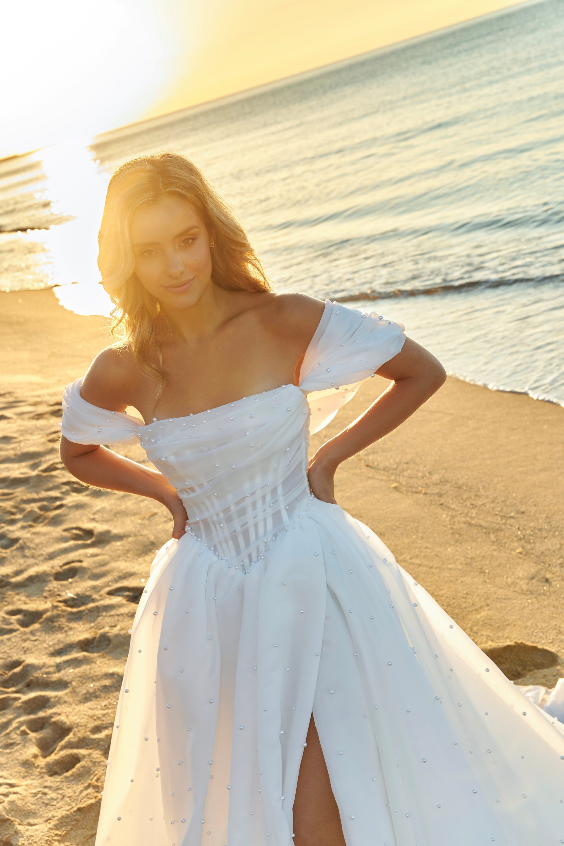Princess A-line organza bridal gown with short off-the-shoulder draped sleeves, pearl details, slit skirt, drop-down waist, and chapel train.