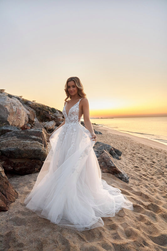 Sleeveless lace A-line bridal gown with spaghetti straps, deep-V neckline, backless zip closure, lace tulle skirt, and chapel train.
