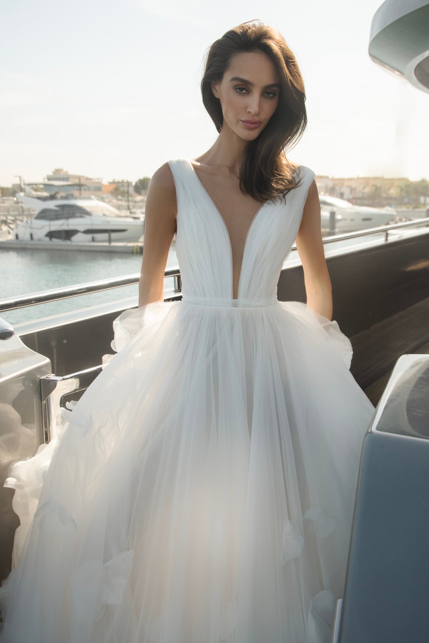 Ethereal tulle ball gown with deep V-neckline and layered airy skirt.