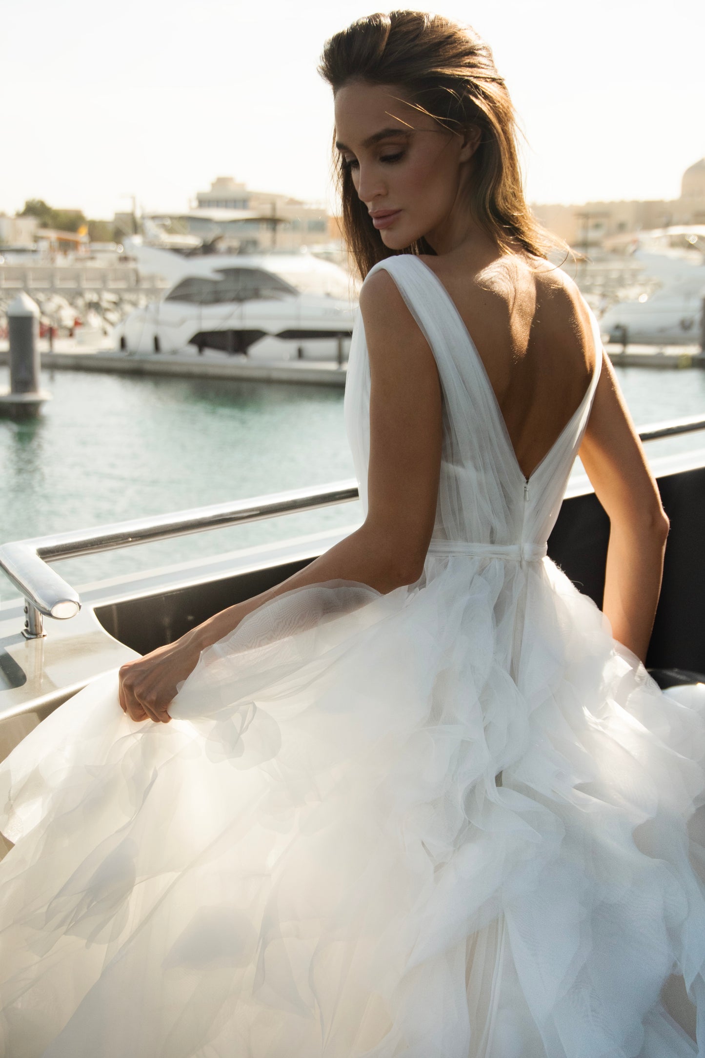 Ethereal tulle ball gown with deep V-neckline and layered airy skirt.
