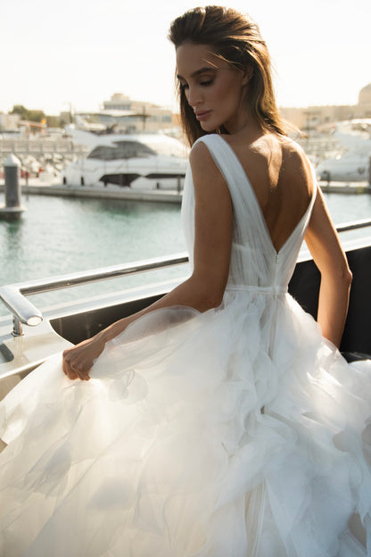 Ethereal tulle ball gown with deep V-neckline and layered airy skirt.