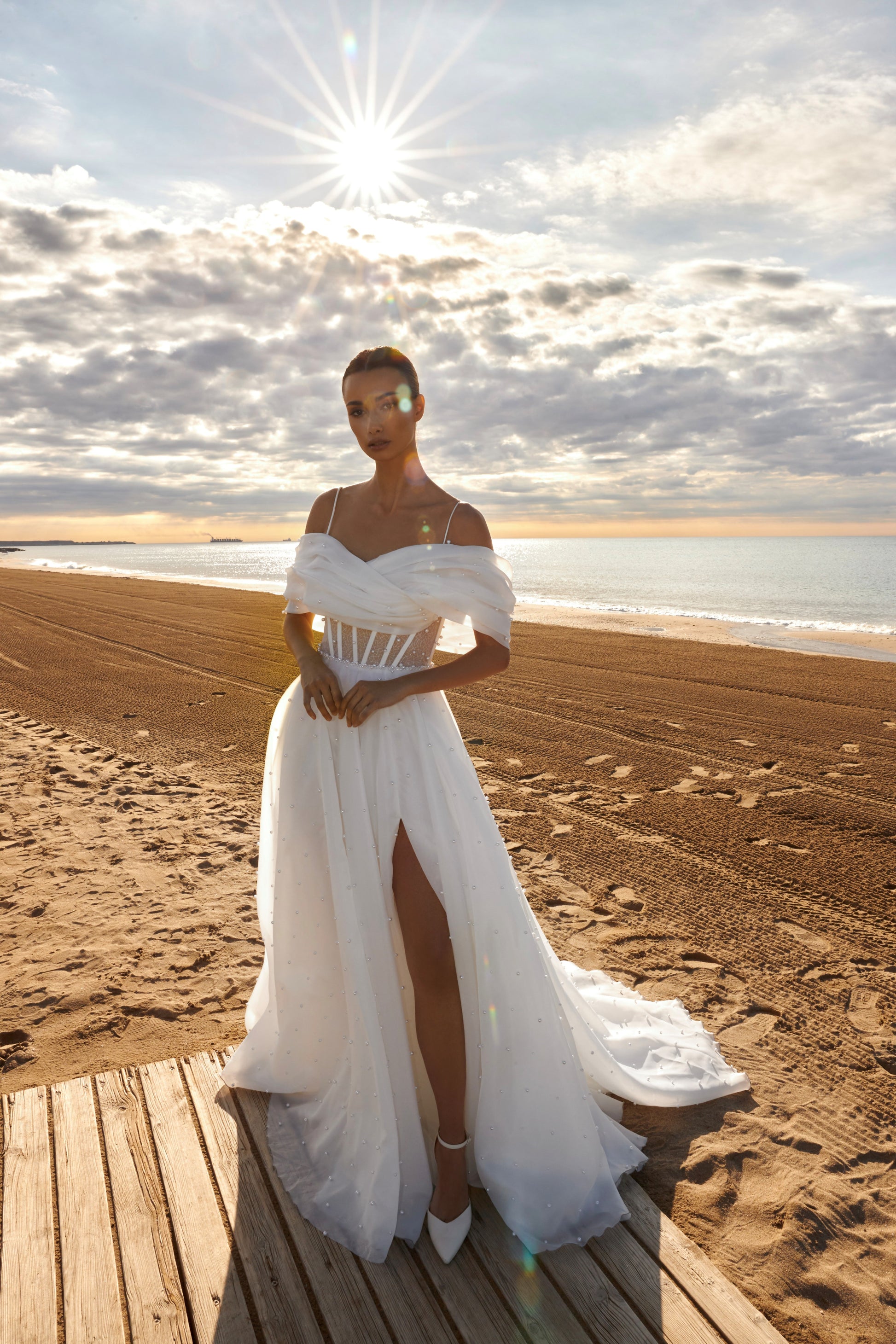 Organza A-line bridal gown with off-shoulder crossed draped neckline, spaghetti straps, pearl details, slit skirt, open back lace-up closure, and court train.