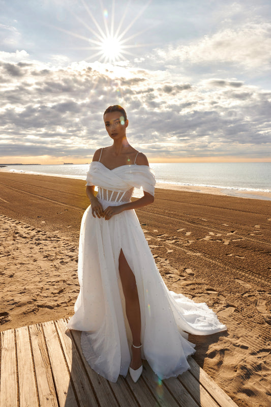 Organza A-line bridal gown with off-shoulder crossed draped neckline, spaghetti straps, pearl details, slit skirt, open back lace-up closure, and court train.