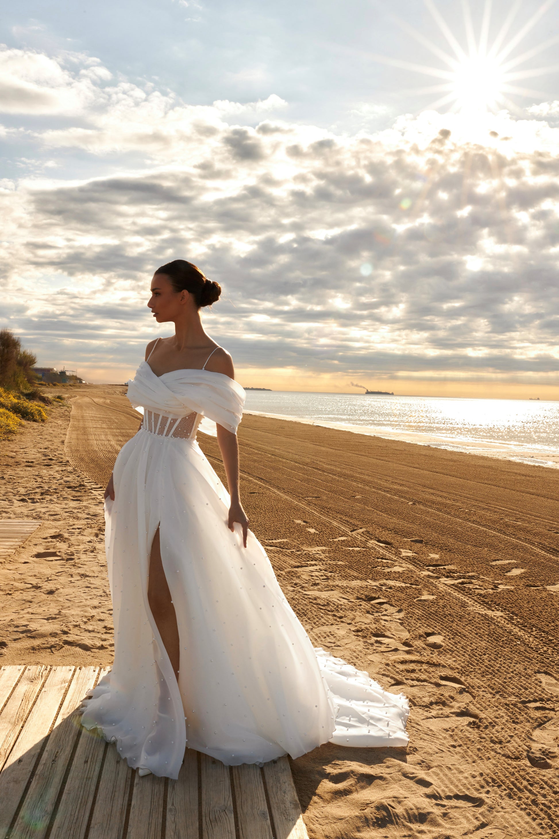 Organza A-line bridal gown with off-shoulder crossed draped neckline, spaghetti straps, pearl details, slit skirt, open back lace-up closure, and court train.