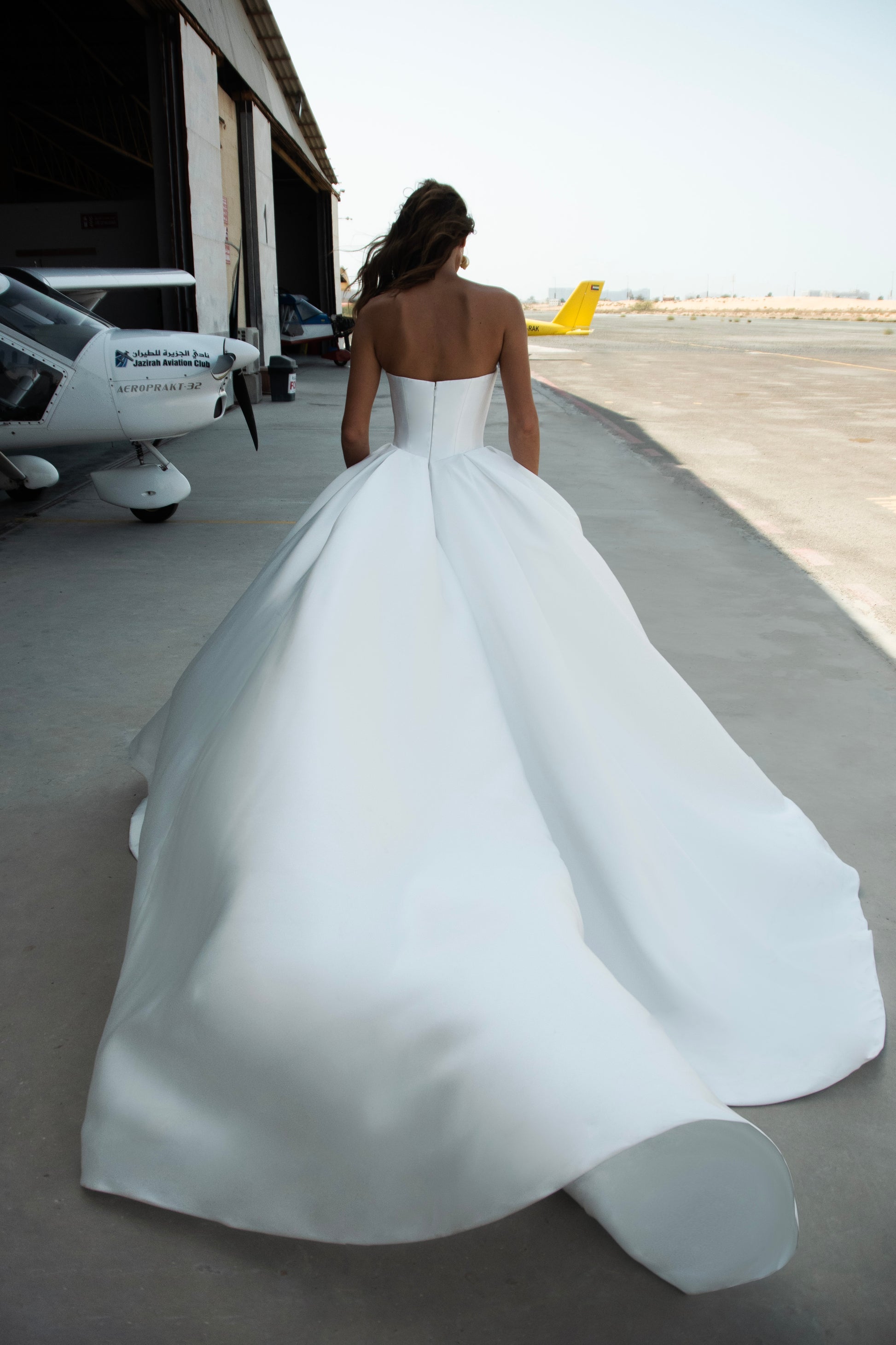 Strapless Mikado wedding dress with sculpted corset bodice, structured waist, and full flowing skirt in luminous white fabric for modern bridal look